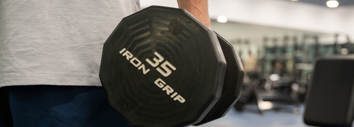 A photo of an Airman holding a weight during his workout